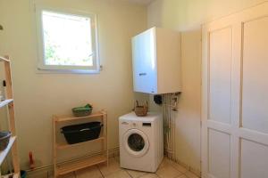 a laundry room with a washing machine and a window at Maison d'architecte in Cébazat