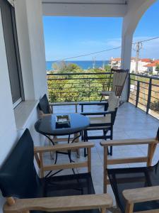 a balcony with tables and chairs and a view of the ocean at Seaview Apartment Agiokampos in Agiokampos