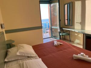 a bedroom with a bed with two towels on it at Abbazia Club Hotel Marotta in Marotta