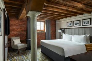 a hotel room with a bed and a chair at Manchester Marriott Victoria & Albert Hotel in Manchester +37 photos