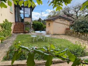 a patio with chairs and a table in front of a house at Le Petit Rousseau - Maison Climatisé - Classé 4 ETOILES in Hurigny