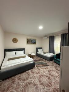 a bedroom with two beds and a couch at Old Del Mar in Vlorë