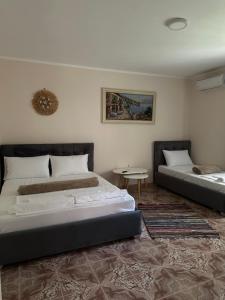 a bedroom with two beds and a table at Old Del Mar in Vlorë