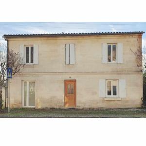 una grande casa in mattoni con una porta marrone di Charmante maison Girondine a La Rivière
