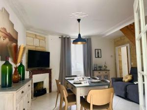 a living room with a table and chairs and a couch at Charmante maison Girondine in La Rivière