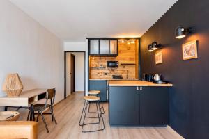 a kitchen with blue cabinets and a table and chairs at Studio au port de Sanary in Sanary-sur-Mer