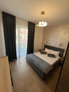 Un dormitorio con una cama y una ventana grande. en sicanT Apartments - Self Check-in, en Constanţa