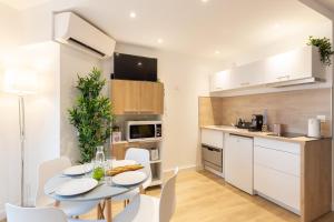 Una cocina y un comedor con mesa y sillas. en GuestReady - Studio Gerland neuf avec terrasse, en La Mulatière