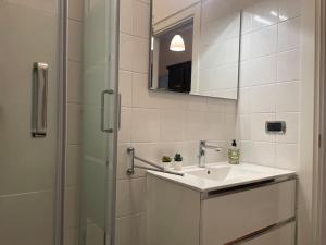 une salle de bain blanche avec un lavabo et une douche dans l'établissement Interno 3 - Vatican Apartment, à Rome