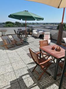 a patio with a table and chairs and an umbrella at CLASSY Penthouse B&B in Imola