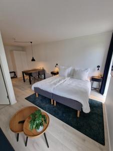 韩德斯泰德Harbour Inn Hundested的一间卧室，里面有一张大床和一张桌子。