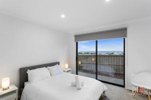 a bedroom with a white bed and a large window at Panoramic Paradise 4-BR San Remo in San Remo