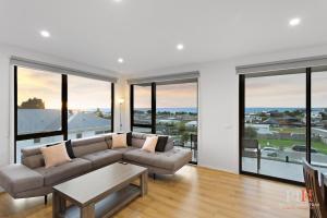 a living room with a couch and large windows at Panoramic Paradise 4-BR San Remo in San Remo