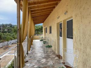 a patio with chairs and tables on a building at Village Holidays - Chelonaria in Chrani