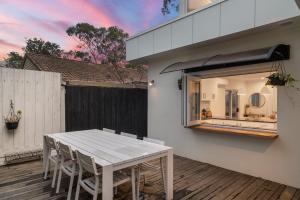 eine Terrasse mit einem weißen Tisch und Stühlen auf einer Terrasse in der Unterkunft Chic Coastal Retreat 3 Bdr Close to Beach in Cowes