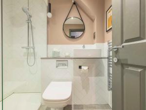 a bathroom with a toilet and a sink and a mirror at Holyrood Aparthotel in Edinburgh