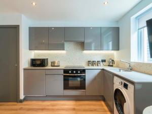 a kitchen with stainless steel appliances and a dishwasher at Holyrood Aparthotel in Edinburgh