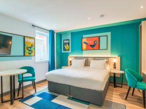a bedroom with a bed and two tables and chairs at Holyrood Aparthotel in Edinburgh