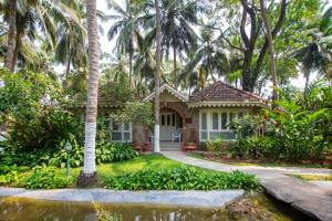 una casa con delle palme davanti di Kairali - The Ayurvedic Healing Village a Palakkad