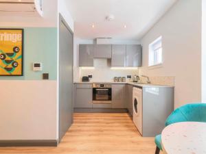 a kitchen with stainless steel appliances and a table at Holyrood Aparthotel in Edinburgh