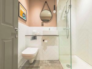 a bathroom with a toilet and a glass shower at Holyrood Aparthotel in Edinburgh