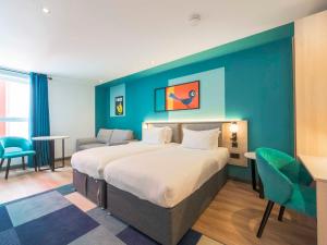 a bedroom with a large bed and a blue wall at Holyrood Aparthotel in Edinburgh