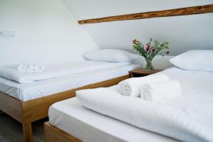 2 letti con lenzuola bianche e un vaso con fiori di Nadwiślańska Apartments - Lipowa, 11km od Zator, Energylandia a Zator