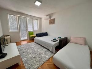 a room with two beds and a table and a couch at CITY CENTER CORNER in Prilep