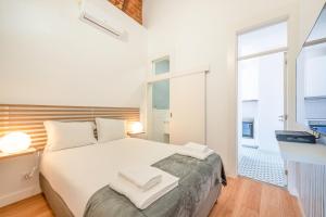 a bedroom with a white bed and a large window at GuestReady - Urban Garden Apartments in Lisbon
