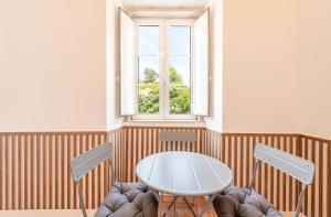 a table and chairs in a room with a window at GuestReady - Urban Garden Apartments in Lisbon +116 photos
