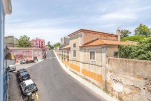 una strada vuota con un'auto parcheggiata sul lato di GuestReady - Urban Garden Apartments a Lisbona