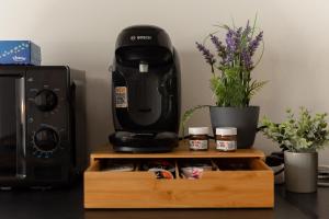 a coffee maker sitting on top of a wooden stand next to a microwave at Paris Métro 7 Parking gratuit in Villejuif +3 photos