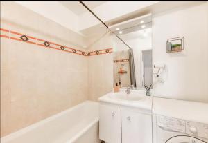 a white bathroom with a sink and a bath tub at Paris Métro 7 Parking gratuit in Villejuif