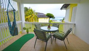 a patio with a table and chairs on a balcony at Sea 7 in Ocho Rios