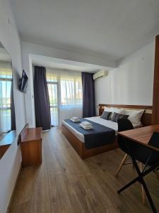 a bedroom with a bed and a desk and a table at Къща Катерков in Sozopol