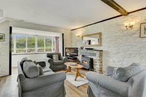 a living room with two couches and a fireplace at Dunkery Cottage Wheddon Cross in Minehead