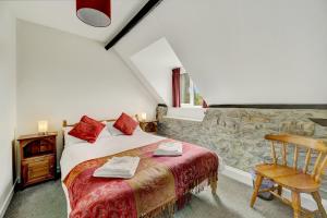a bedroom with a bed and a chair in a room at Dunkery Cottage Wheddon Cross in Minehead