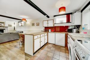 una cucina con mobili bianchi e un piano di lavoro di Stable Cottage Wheddon Cross a Minehead Altre 31 foto