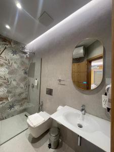 a bathroom with a sink and a toilet and a mirror at Klaudia Apartments in Himare