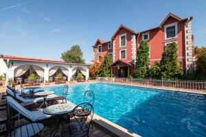 a swimming pool with tables and chairs next to some buildings at Casa del Sole Boutique Hotel Timisoara in Timişoara