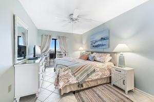 a bedroom with a bed and a desk and a television at Plantation Dunes Condos in Gulf Shores