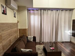 a living room with a brown couch in front of a window at Magic Studio Pool View, New Cairo in Cairo