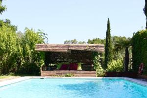 a swimming pool with a pergola next to a house at La Lolita ( Adults Only ) in Sant Mart&iacute; Vell