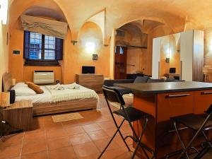 a room with a bed and a desk with chairs at casa Giovanna - Piazza San Michele Central Studio! in Lucca