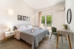 a bedroom with a bed and a table and a desk at Shady Tree Villa in Ialyssos