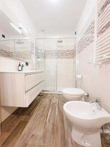 a white bathroom with a toilet and a sink at Vigentino Suites in Milan +51 photos