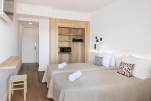 a white bedroom with a large white bed with pillows at htop Amatista #htopBliss in Lloret de Mar +37 photos