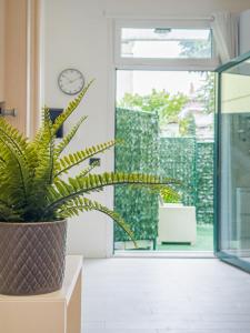 a plant sitting on a table next to a door at Vigentino Suites in Milan
