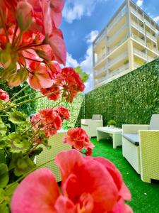 a garden with red flowers in front of a building at Vigentino Suites in Milan