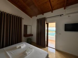 a bedroom with a bed and a view of the ocean at Dine Hotel in Ksamil